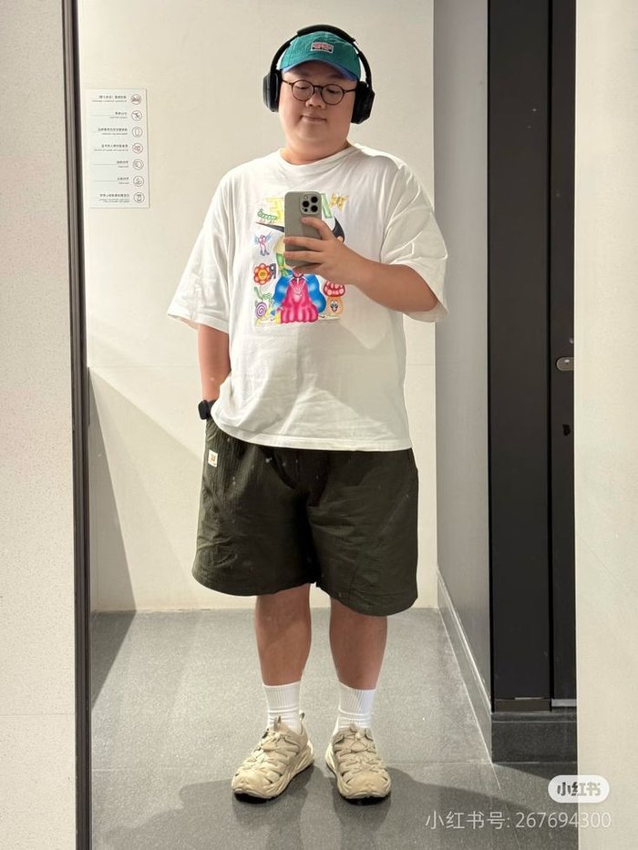 Outfit — graphic tee, olive shorts, cap and headphones