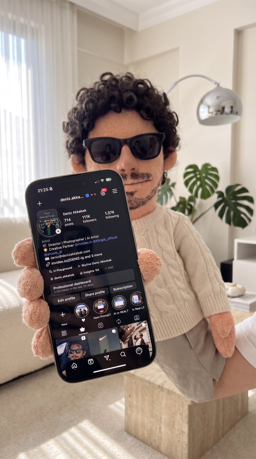Output — the phone still. The phone sits fully inside the frame, the screenshot fitted edge to edge, terry fingers wrapped around the edges, the puppet an arm’s length back in soft focus. The screen is legible but not letter-perfect — which is exactly why the video gets the original screenshot as a third reference.