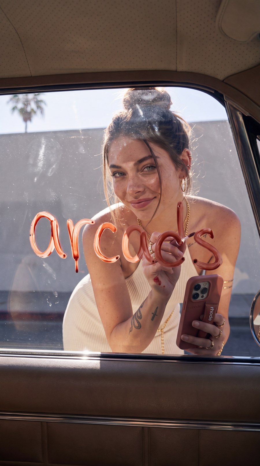 Output — the signature still. Six wet letters on the outside of the glass, reading correctly from the passenger seat; the applicator an inch from the final s.