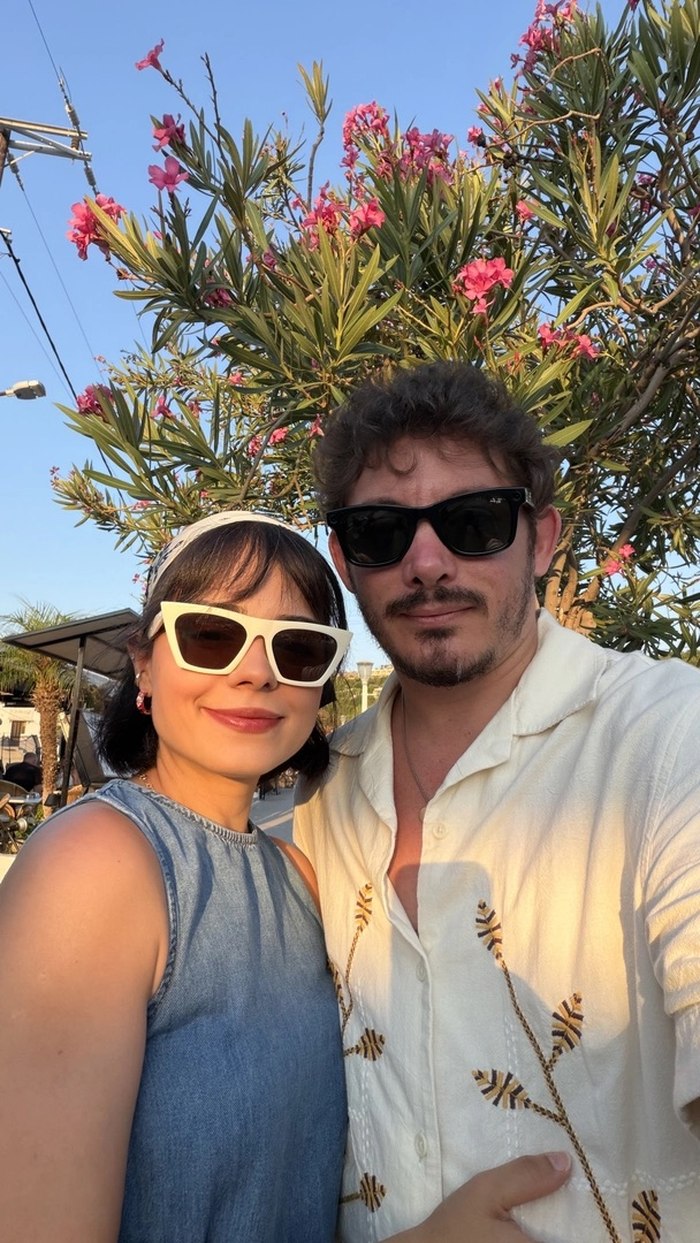 @Image 1 — the identity lock: both faces exactly, his embroidered resort shirt, her scarf, cat-eyes — and the denim dress that @Image 2's outfit clause pins in place.